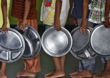 Children holding plates wait in a queue to receive food at an orphanage in the southern Indian city of Chennai May 28, 2014. REUTERS/Babu (INDIA - Tags: SOCIETY)
