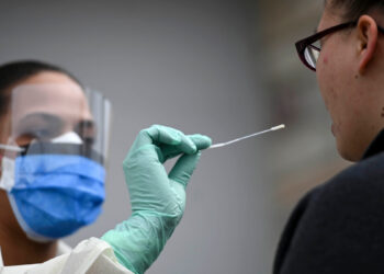 Fridley, MN March 10: Reece Wallaker, a medical assistant with M Health Fairview, administered a COVID-19 test to an actor and fellow Fairview employee, Nichole Brown, outside the M Health Fairview Fridley clinic Tuesday. (Photo by Aaron Lavinsky/Star Tribune via Getty Images)