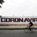 A coronavirus sign is seen on the wall as a man passes on a bicycle as the coronavirus disease (COVID-19) continues in Mexico City, Mexico April 15, 2020. REUTERS/Carlos Jasso