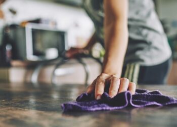 Close-up of a hand with a rag wiping a table