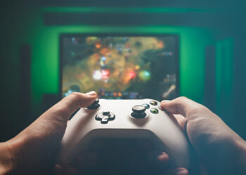 Man is playing on the console. Man holding gamepad and playing RPG