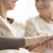 Close-up of person touching hand of senior woman. Caregiving in the nursing home