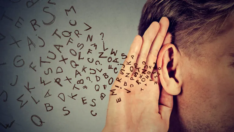man holds his hand near ear and listens carefully alphabet letters flying