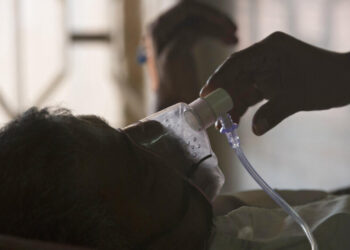 FILE - In this March 24, 2018 file photo, a relative adjusts the oxygen mask of a tuberculosis patient at a TB hospital on World Tuberculosis Day in Hyderabad, India. The number of people killed by tuberculosis has risen for the first time in more than a decade, largely because fewer people got tested and treated as resources were diverted to fight the coronavirus pandemic, the World Health Organization said in a report released Thursday, Oct. 14, 2021. (AP Photo/Mahesh Kumar A., file)